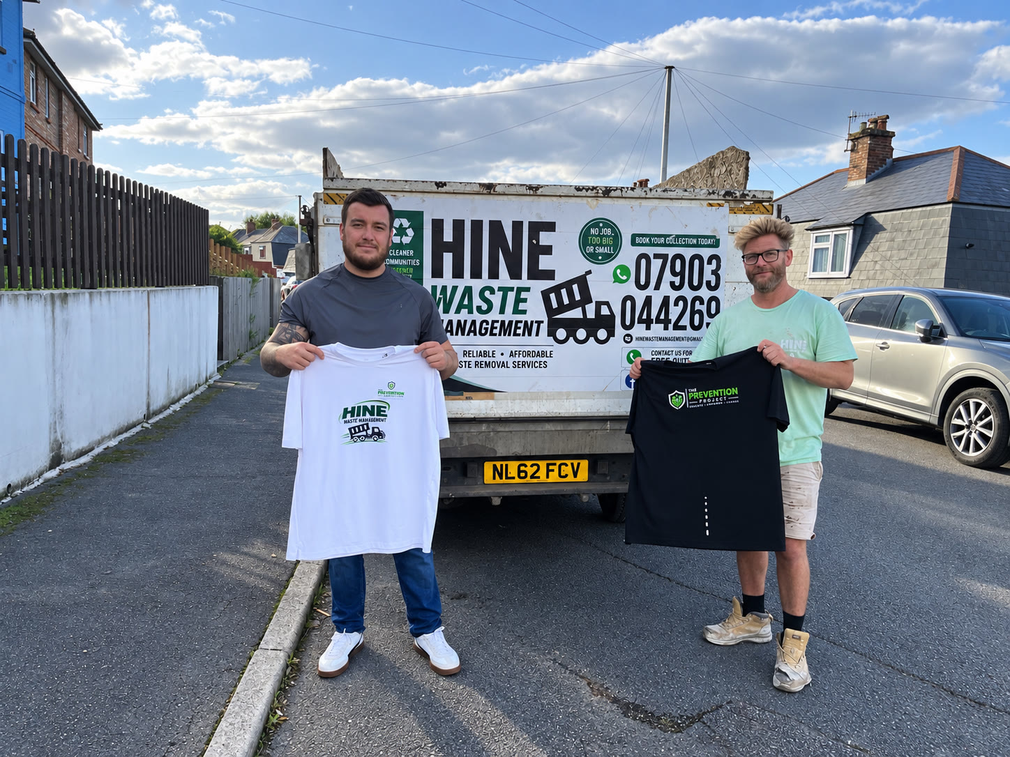 Macauley South and Jamie from Hine Waste Management holding branded Prevention Project kit shirts in front of a Hine Waste Management truck